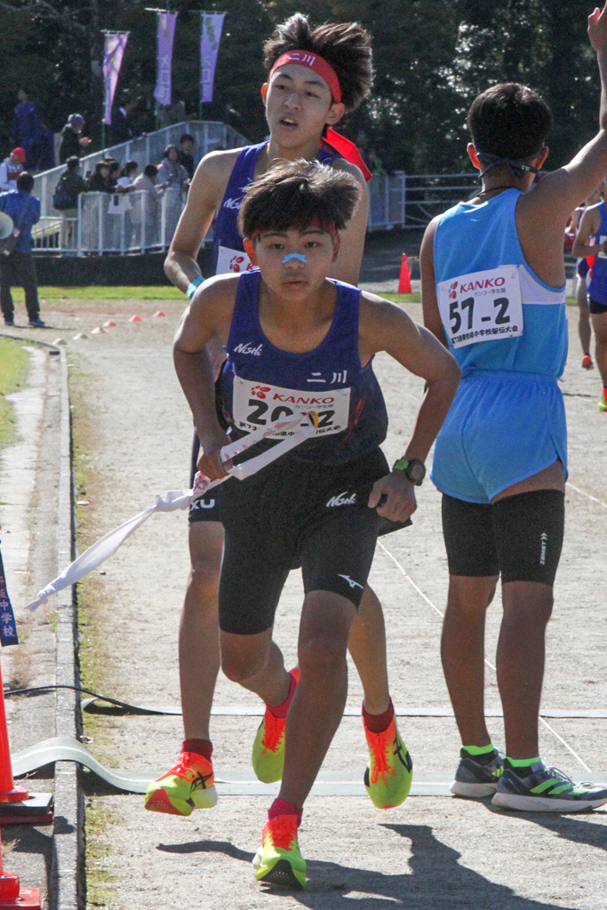 １区トップでたすきをつなぐ二川。１走河合琢留（後方）から２走神谷大夢へ