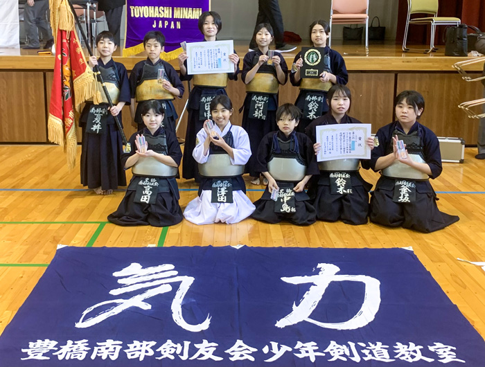 小学生の部で優勝した豊橋南部少年剣道教室の子どもたちが並ぶ。足元には「気力」と書かれた横断幕